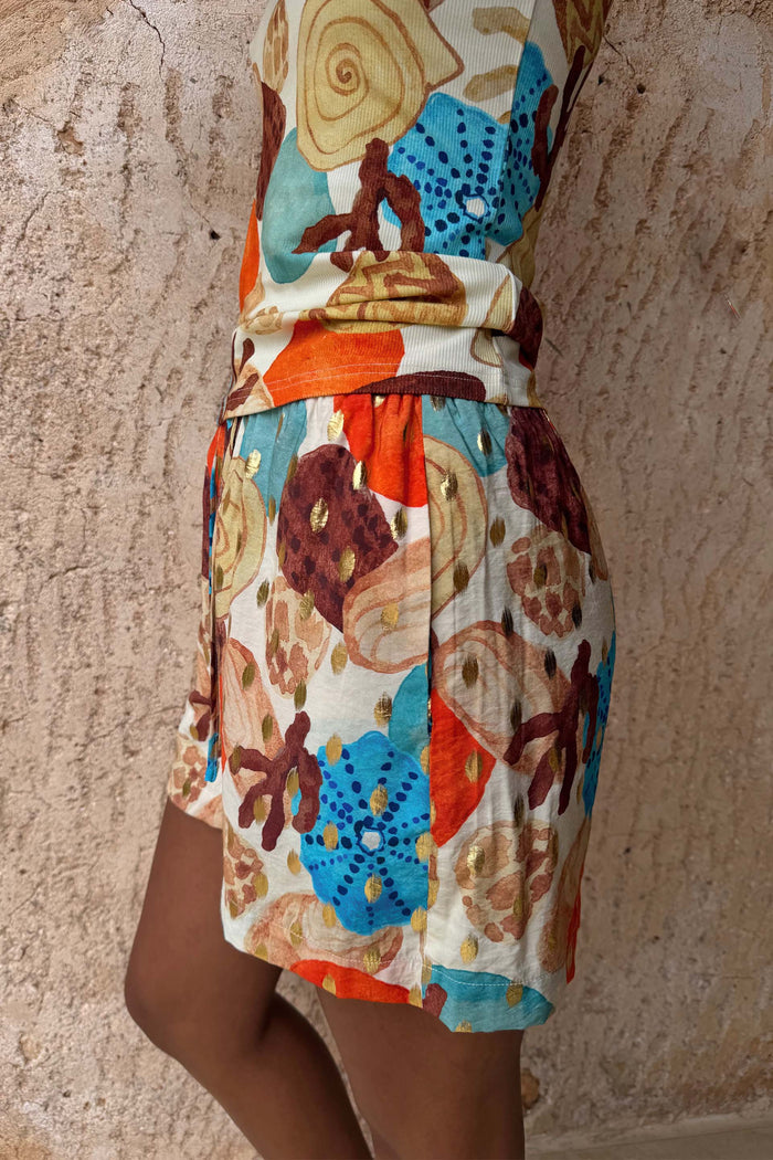 Shell Ellie Shorts featuring an abstract shell print in blue and orange with metallic gold detailing.