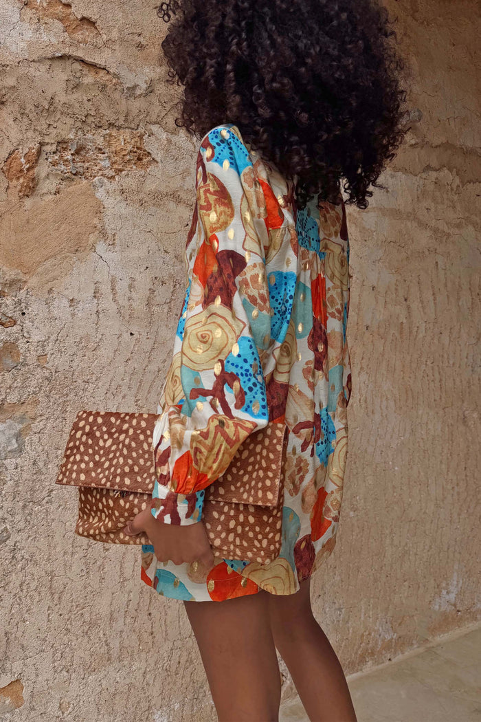 Shell Marley Shirt in a multi abstract shell print with metallic detailing and a leopard print clutch.