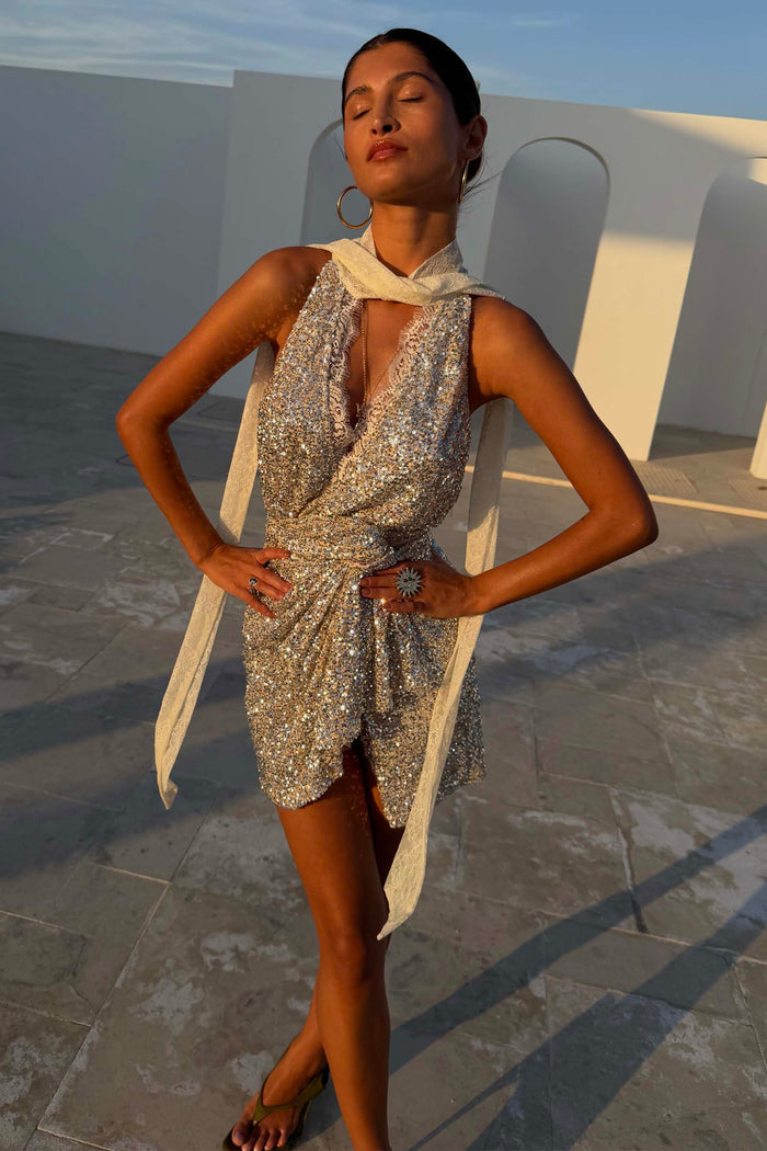 Silver Sequin Mini Jaspre Skirt and matching top styled with a cream lace scarf in the golden hour sun.