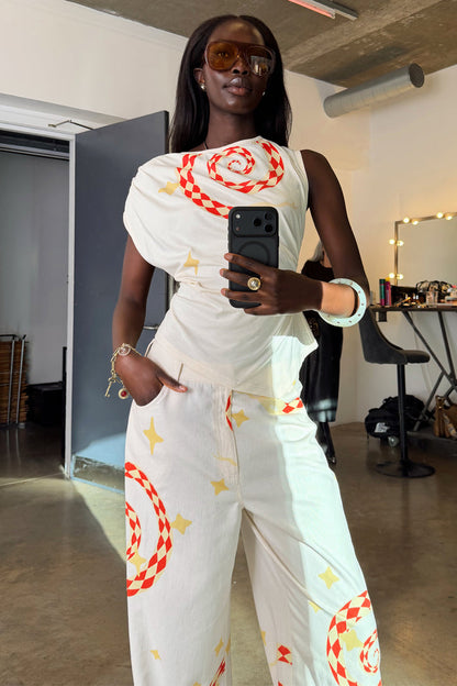 White Snake Asymmetric Top with red snake and star motifs, styled as a co-ord in a mirror selfie.