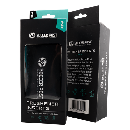 Two black boxes of Soccer Post Freshener Inserts are shown side-by-side against a white background. One box is positioned to show the front with a clear window revealing a black insert inside, while the other shows the side and back with product descriptions and a barcode. Both boxes feature teal accents, the brand logo, and icons for shoes and athletic gear.