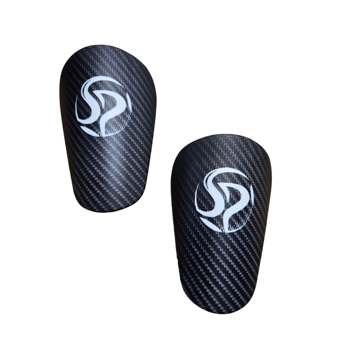 Pair of black shin guards with a carbon fiber pattern and white circular logos, shown against a black background.