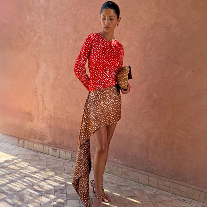 Spliced Fawn Mini Nola Tie Dress in red and brown spotted prints featuring long sleeves and a long side drape.