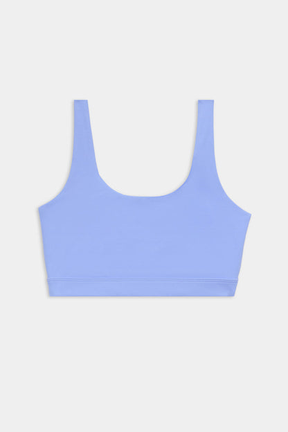 A light blue sports bra with wide shoulder straps and a scoop neckline, displayed on a plain white background.