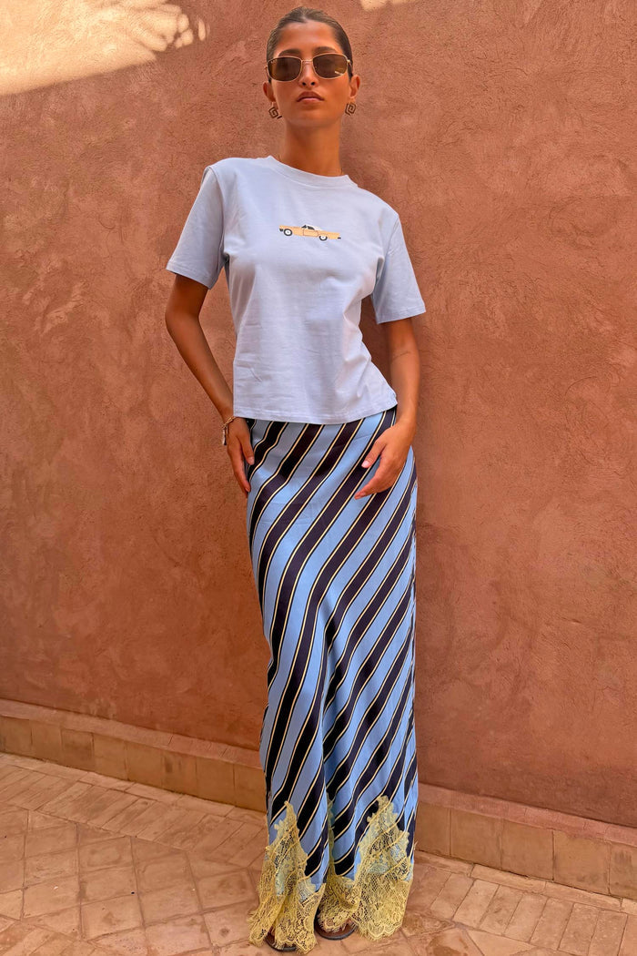 Stripe Maeva Skirt with blue diagonal stripes and a yellow lace hem, styled with a light blue tee.