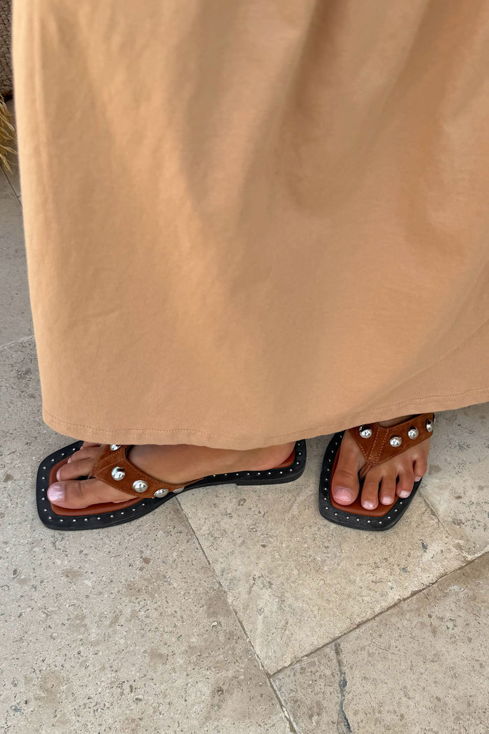 Tan Leather Stud Sandals with a square toe and silver stud detailing, worn with a coordinating tan dress.