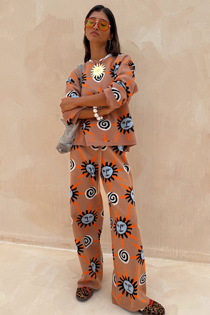 Tan Sun knit trousers with sun and swirl motifs, styled as a co-ord. Model is 5ft4” and wears size M.