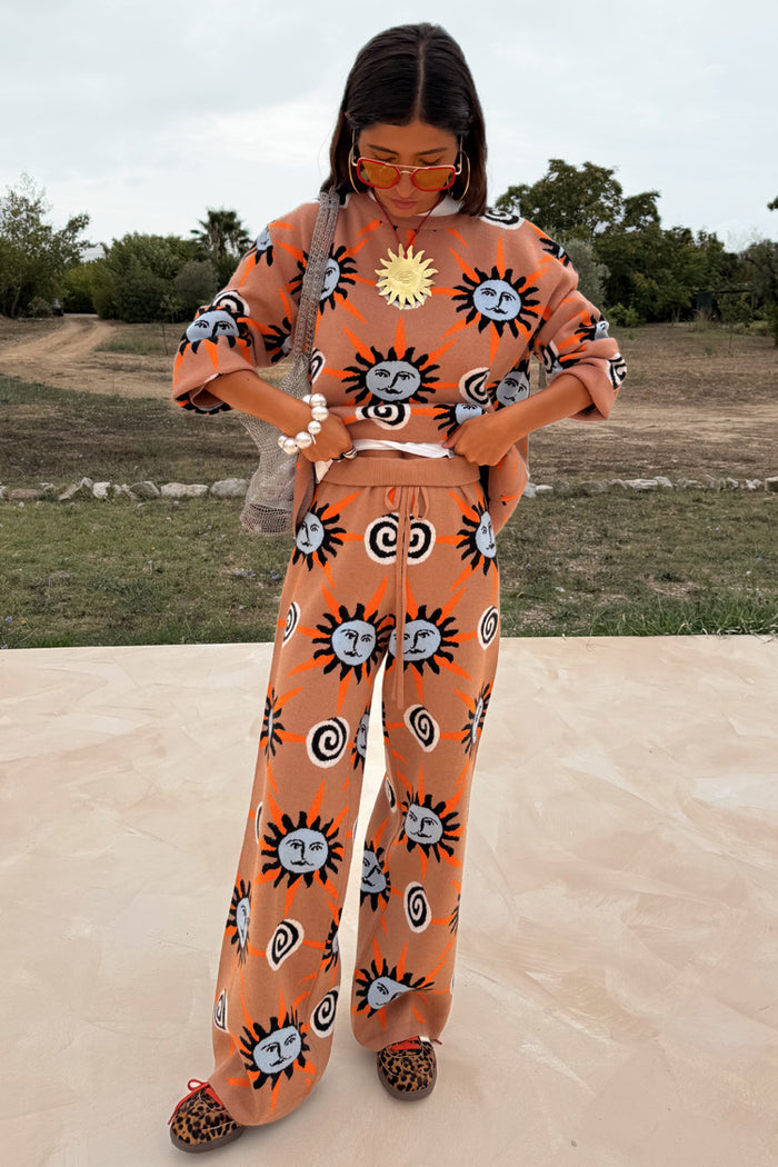Tan Sun Trousers with sun motifs in stretch knit, styled as a co-ord on a 5ft4 model wearing size M.