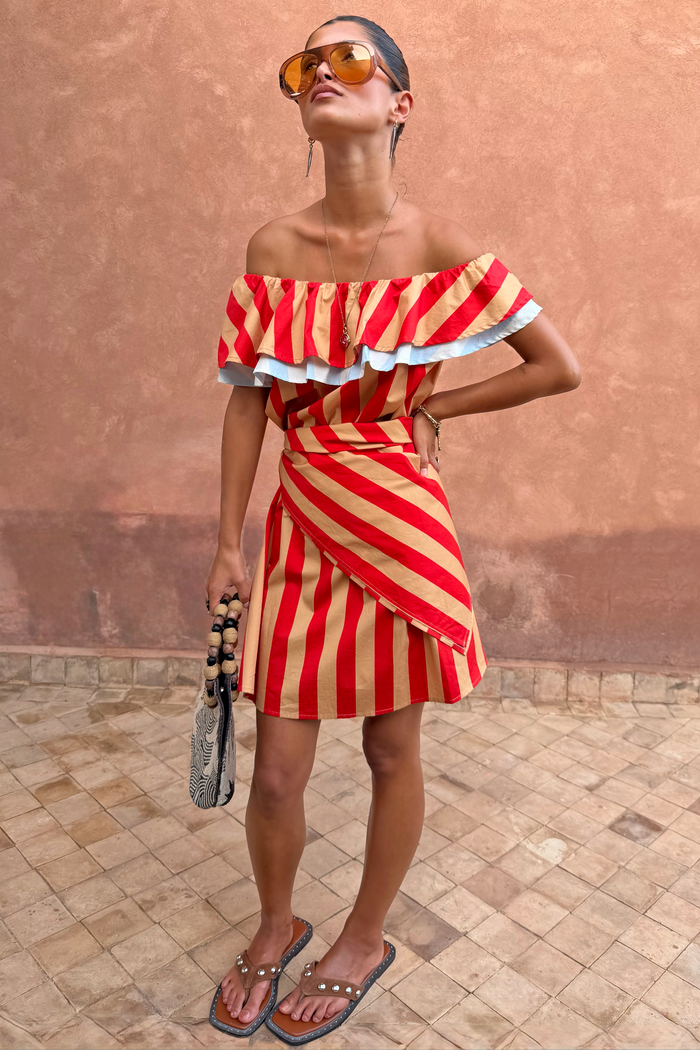 Tomato Stripe Scarf styled as a red and tan multi-wear off-the-shoulder dress on a model.