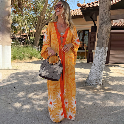 Yellow Sun Kimono in Soleil print with orange sun motifs and contrast trim, styled for a summer vacation look.