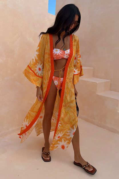 Yellow Sun Kimono with a Soleil sun print and contrast trim, styled over a bikini for a vacation-ready look.