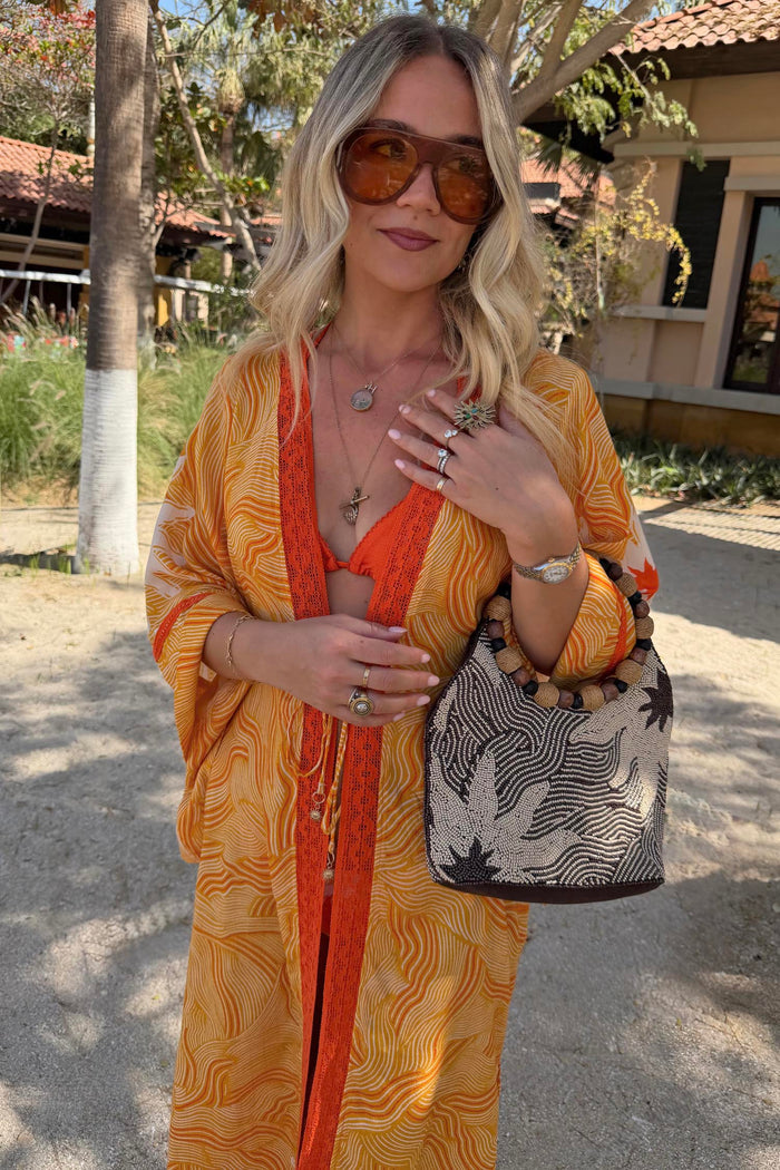 Yellow Sun Kimono in the Soleil print with orange contrast trim and wide sleeves, perfect for vacation styling.