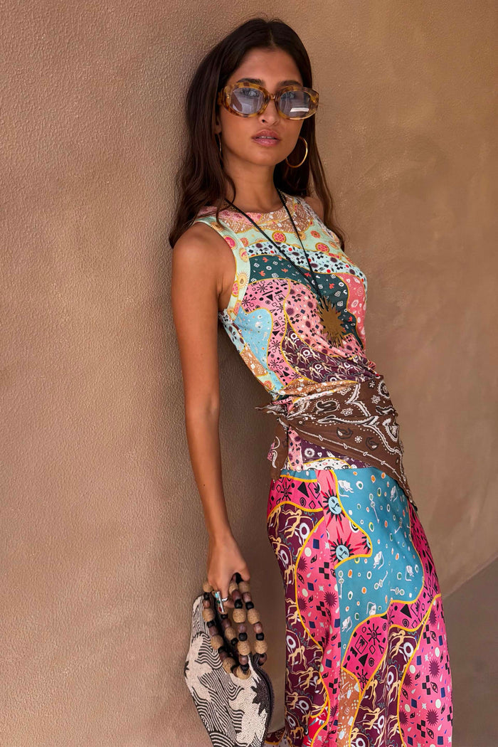 Yellow Tort Wiggle Arm Sunglasses with light blue lenses, styled with a colourful patchwork print dress and gold hoops.